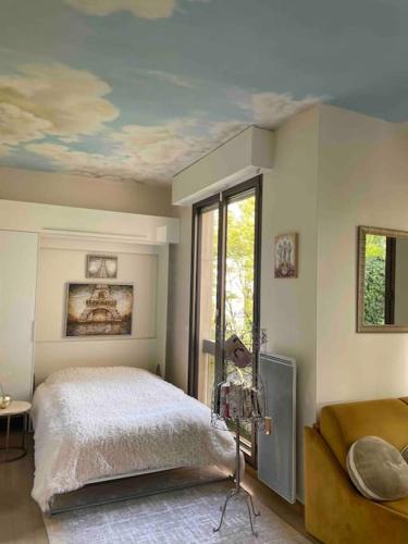 - une chambre avec un lit et une fenêtre au plafond dans l'établissement Studio cadre bucolique Neuilly Paris, à Neuilly-sur-Seine