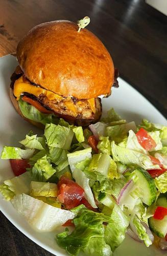 a sandwich and a salad on a white plate with a sandwich and a salad at Acadian Hotel in Stephenville