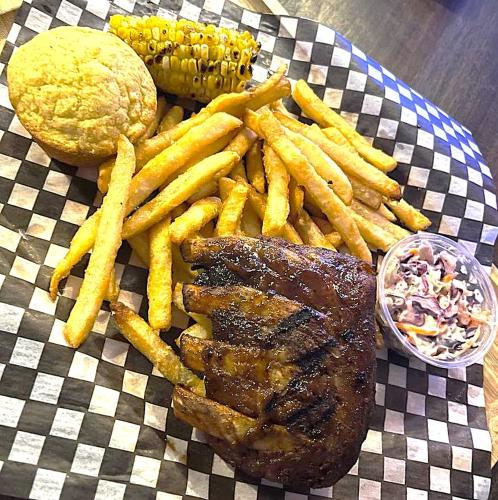 a plate of food with steak fries and a hamburger at Acadian Hotel in Stephenville