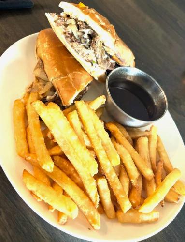 a plate of food with a sandwich and french fries at Acadian Hotel in Stephenville