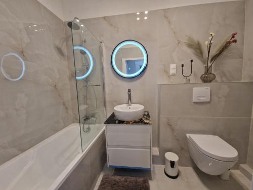 een badkamer met een wastafel, een toilet en een spiegel bij Danube Wonder View apartment in Boedapest