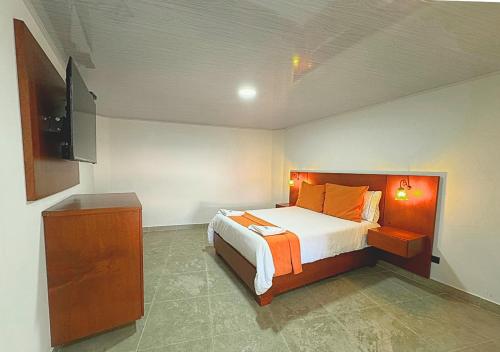 a bedroom with a bed and a television in it at VillaLoren in San Antonio del Tequendama