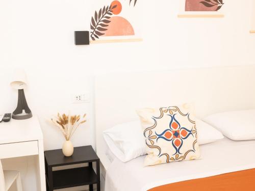 a white bed with two pillows on it at La Trinacria Rooms in Trapani