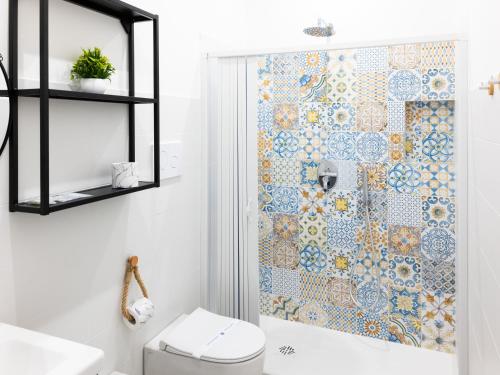 a bathroom with a toilet and a shower curtain at La Trinacria Rooms in Trapani