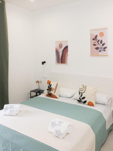 two beds in a room with white walls at La Trinacria Rooms in Trapani