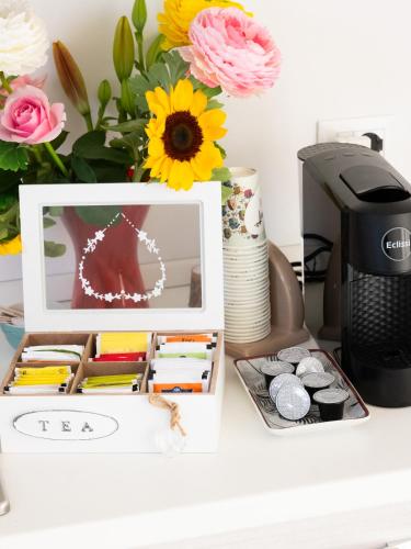 a desk with a picture and a printer and flowers at La Trinacria Rooms in Trapani