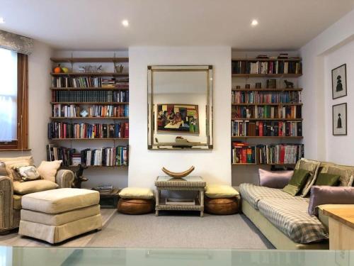 a living room with a couch and a mirror at Quiet Kensington flat ideal for central London in London