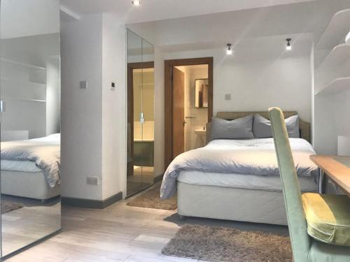 a bedroom with two beds and a mirror at Quiet Kensington flat ideal for central London in London