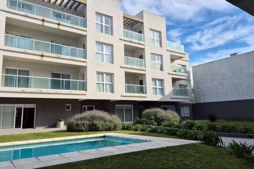 een appartementencomplex met een zwembad ervoor bij Moderno 2 Ambientes con cochera in Tandil