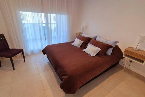 een slaapkamer met een groot bed en een raam bij Moderno 2 Ambientes con cochera in Tandil