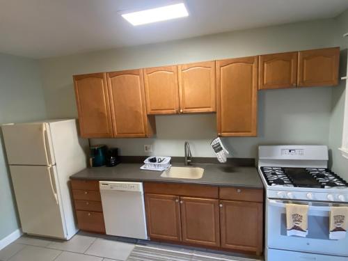 a kitchen with wooden cabinets and a white refrigerator at Home Away From Home in Baltimore