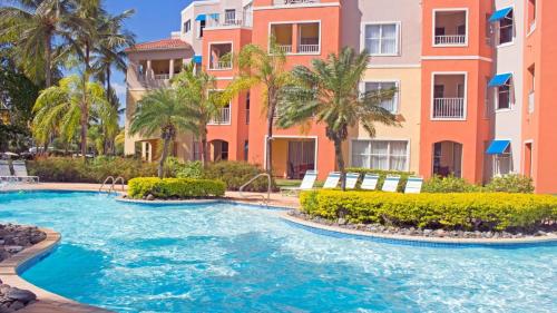 a pool in front of a building with palm trees at Palm View in Humacao