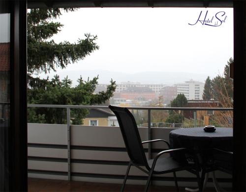 a table and a chair on a balcony with a view at Hotel Del Sol in Bad Wildungen