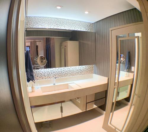 Un baño con dos lavabos y un espejo grande. en Frente mar, espaço e conforto, en Balneário Camboriú