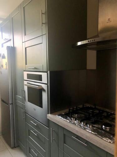 une cuisine avec une cuisinière et un réfrigérateur dans l'établissement Appartement 2 chambres à Massy TGV, à Massy