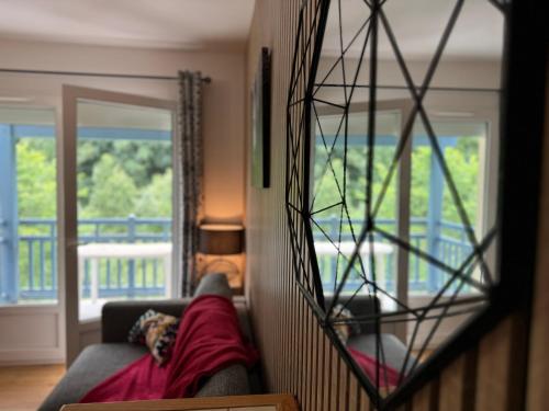 un salon avec un canapé et un grand miroir dans l'établissement T3 duplex 6 couchages parking et balcon sud, à Cauterets