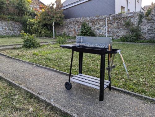 une table avec un ordinateur dessus dans une cour dans l'établissement Le Jardin en centre ville - ANCV accepté, à Granville