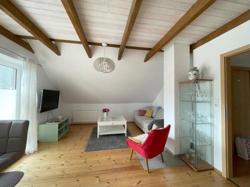 a living room with a red chair and a couch at Hennis Huuske in Krummhörn