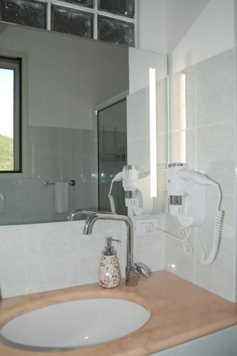 ein Badezimmer mit Waschbecken und Spiegel in der Unterkunft Mini Red Hub - Design Apartment in SantʼAgapito