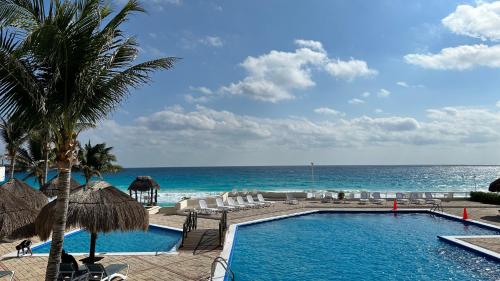 a swimming pool with a view of the ocean at Cancun beach by Brisas in Cancún