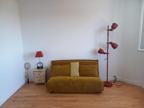 un salon avec un canapé et une lampe dans l'établissement Charmant appartement aux chalets, à Toulouse