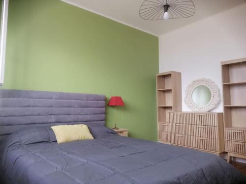 - une chambre avec un lit bleu et un mur vert dans l'établissement Charmant appartement aux chalets, à Toulouse