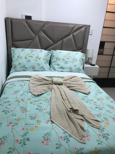 a bed with a blanket with a bow on it at Albano Habitación con cocina y baño in Mariscal Castilla