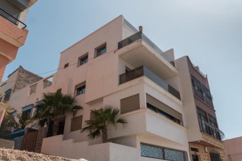 a building with palm trees in front of it at tayyurt host in Agadir