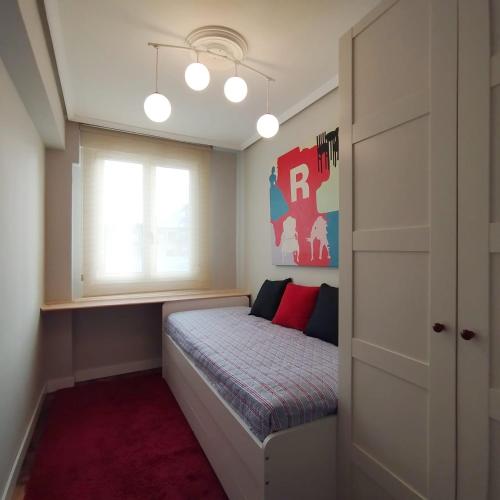 Un dormitorio pequeño con una cama con ventana. en Quédate en casa Titi, en Santander
