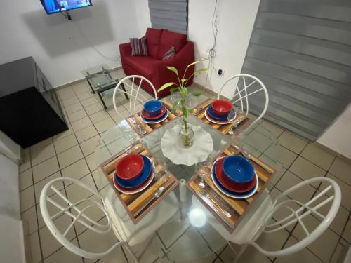 a glass table with plates and a vase on it at Departamento Vallarta in Puerto Vallarta