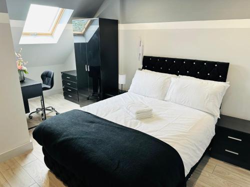 海斯Letzi Premium Cozy Retreat Private En-Suite Rooms, Heathrow Airport的卧室配有黑白床和书桌。