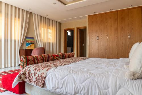 a bedroom with a large white bed and wooden cabinets at tayyurt host in Agadir