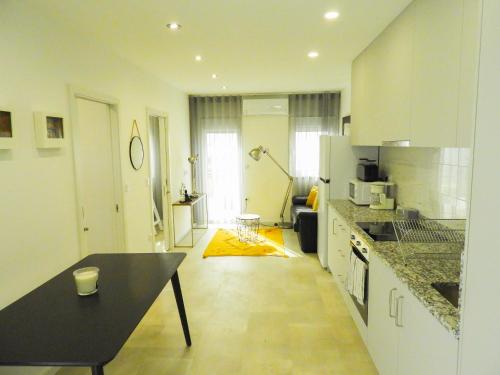 a kitchen with a table and a black counter top at Casinha dos Carris in Valença