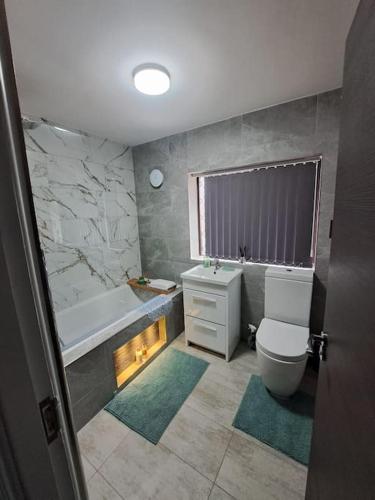 a bathroom with a tub and a toilet and a sink at City Centre Semi-Detached-House in Nottingham