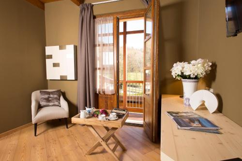 a living room with a table and a chair and a window at La Burla in Borgosesia