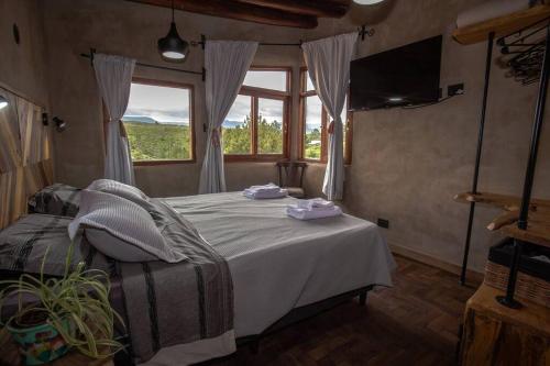 una camera da letto con un letto e una grande finestra di Terracota Casa Eco Intiyaco Cordoba a Atos Pampa