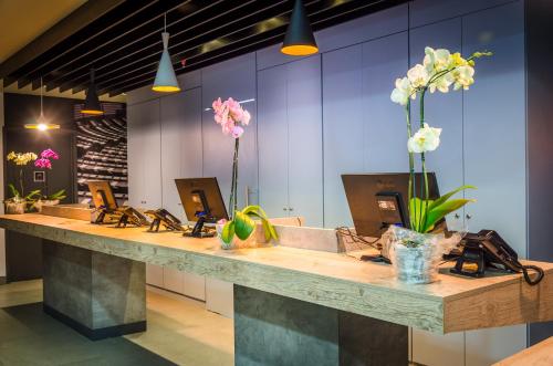 a long counter with a row of sinks and flowers at Ibis Porto Alegre Assis Brasil in Porto Alegre