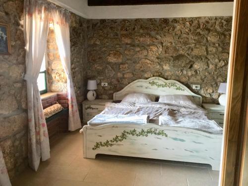 a bedroom with a bed and a stone wall at Family friendly house with a swimming pool Bribir, Novi Vinodolski - 23474 in Bribir