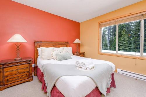 Un dormitorio con una cama grande con paredes naranjas. en Best Ski-in out 3 Bdrm Chalet, with Hot Tub, en Big White