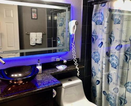 a bathroom with a toilet and a sink and a mirror at Cozy Galveston Beach Front Condo in Galveston