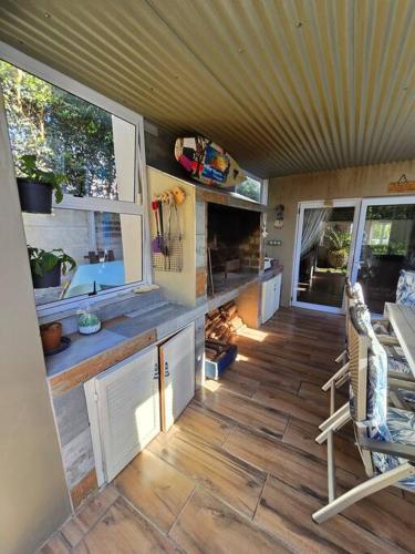 an interior view of a tiny house with windows and a wooden floor at Vibe Beach House in Herolds Bay