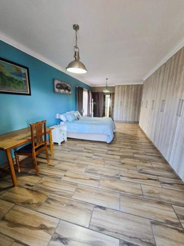 a bedroom with a bed and a table and a table sidx sidx sidx at Vibe Beach House in Herolds Bay