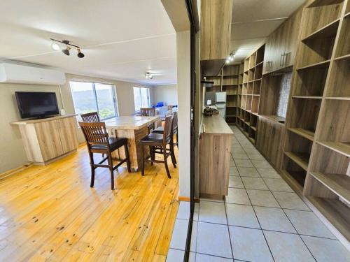 a kitchen and dining room with a table and chairs at Vibe Beach House in Herolds Bay