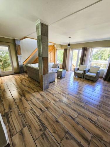 a large living room with wood floors and a fireplace at Vibe Beach House in Herolds Bay