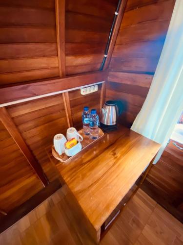 a wooden bench in a small boat with drinks on it at VILLA IPSA in Munduk