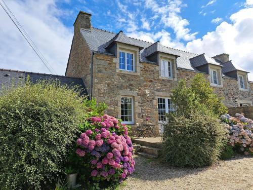 a large brick house with flowers in front of it at Stone House in Brittany near the Sea in Lannilis