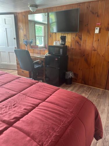 a bedroom with a bed and a desk and a television at Starlight Inn in Bennington