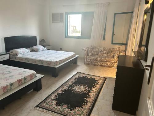 a living room with two beds and a rug at Villa 123 in El Alamein