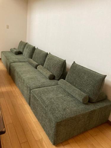 a green couch sitting in a living room at 黒川　天空の城 in Minamioguni