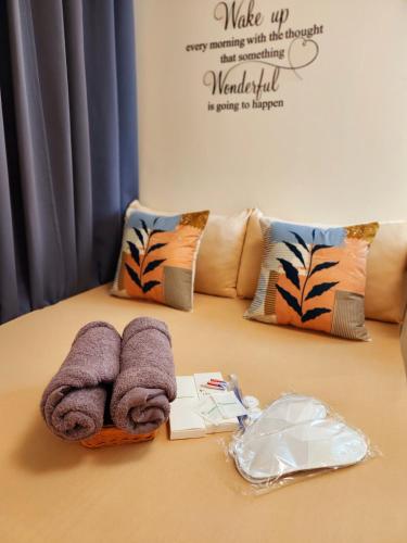 a table with towels and pillows on a bed at SleepScape Staycation in Manila